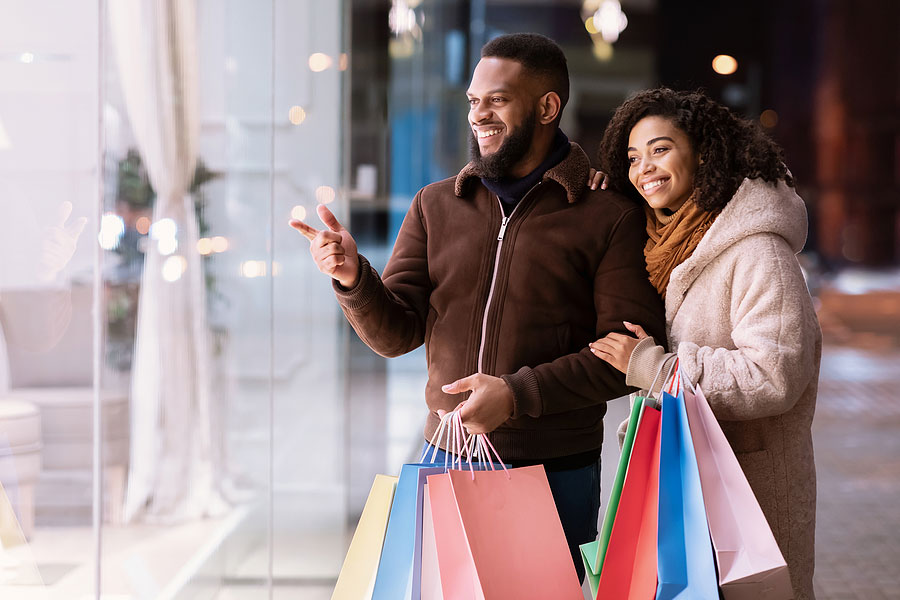 couple looking and pointing at mall window